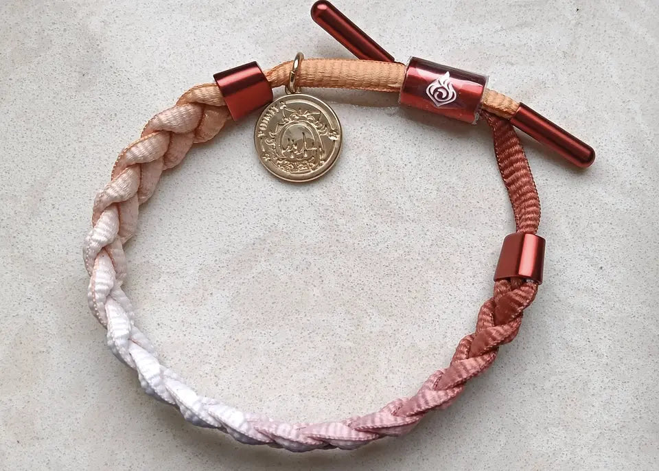 Customer photo showing a pink gradient Genshin Impact character-inspired braided bracelet displayed with original packaging box