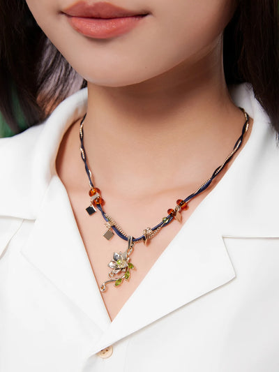 Tighnari brooch featuring floral metal design worn on shirt with decorative chain detail