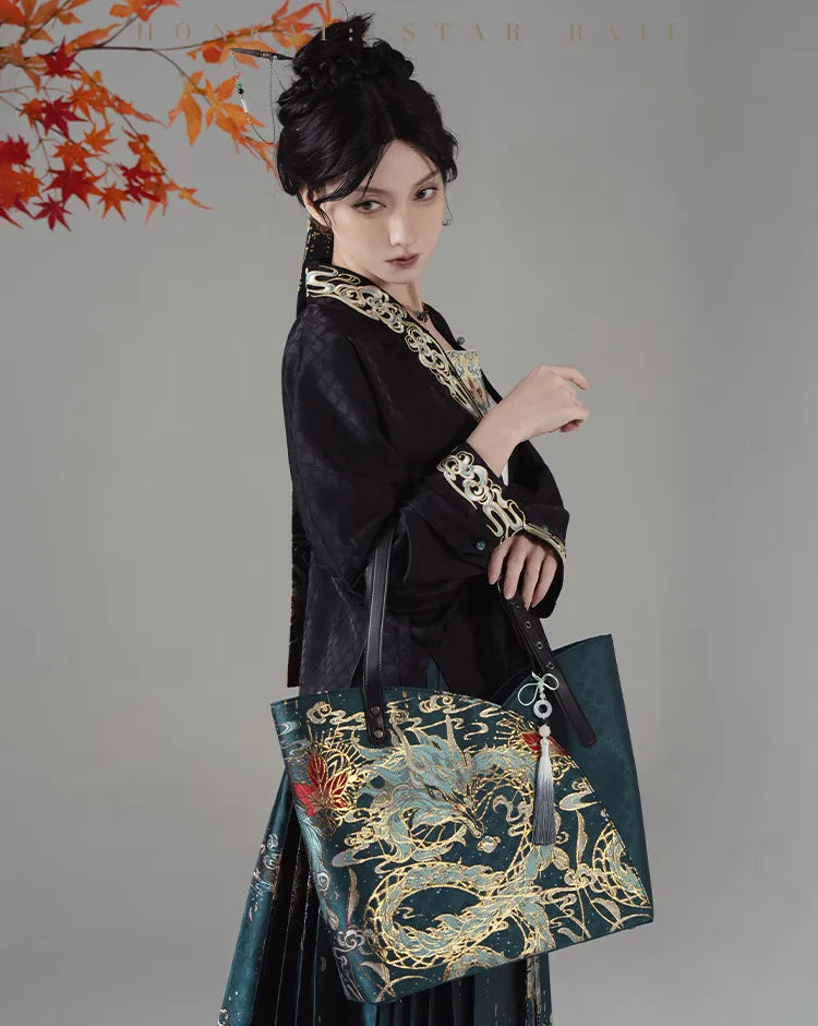 Model carrying Dan Heng Imbibitor Lunae Tote Bag with matching teal Mamian Skirt and white blouse