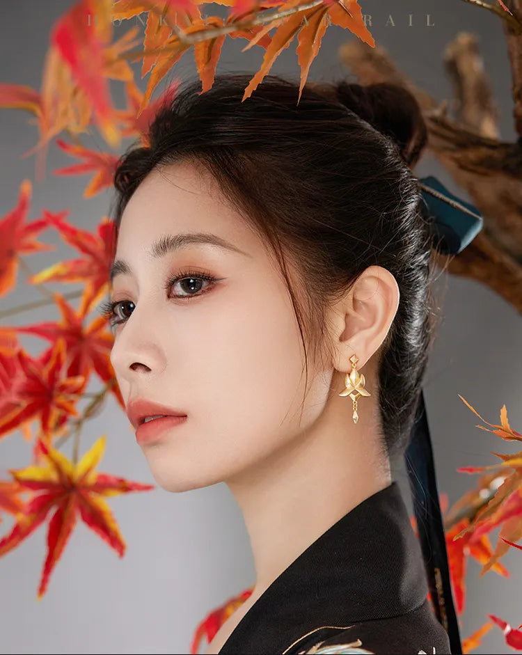 Dan Heng Imbibitor Lunae Water Lotus Ear Cuff displayed against autumn maple leaves