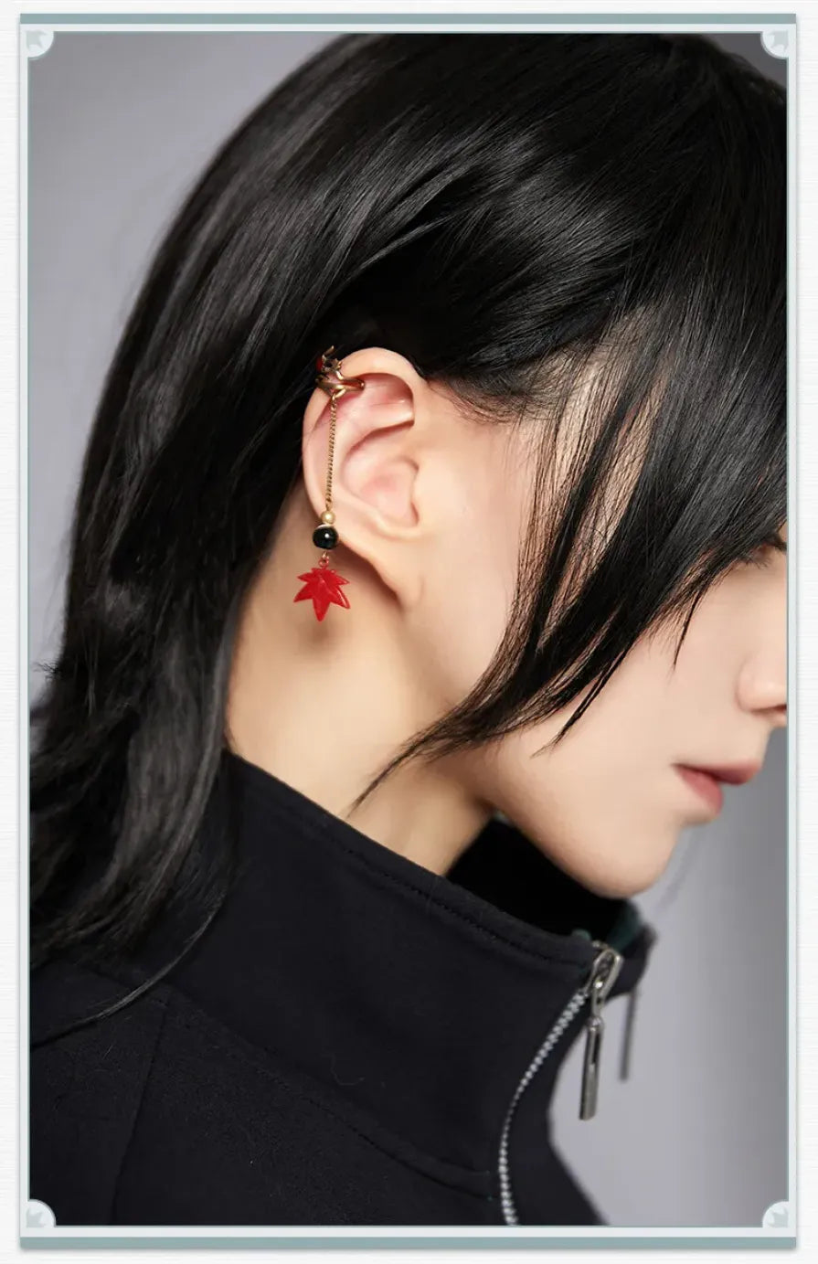 Close-up details of Dan Heng ear clips with dragon blade and red maple leaf charms