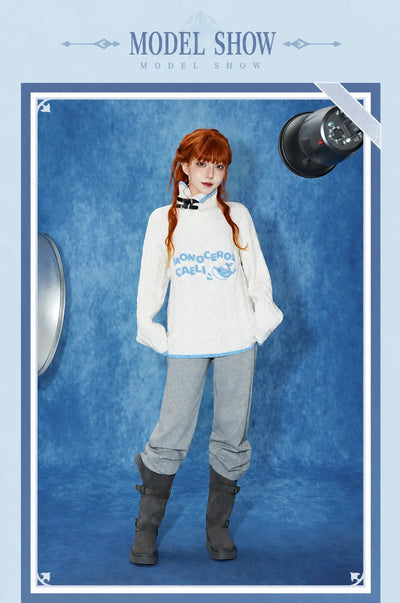 Female model wearing the Tartaglia white cable-knit sweater